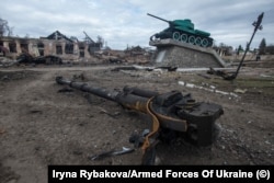 უკრაინა. სუმის რეგიონი. ქალაქი ტროსტიანკა. მეორე მსოფლიო ომის საბჭოთა პერიოდის დაზიანებული მონუმენტის ფონზე თანამედროვე საბრძოლო მანქანის ნაშთი.