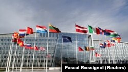 ნატოს და ალიანსის წევრი სახელმწიფოების დროშები ნატოს შტაბ-ბინის წინ.