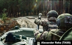 Ruski dobrovoljci voze se oklopnim transporterom u Donjeckoj oblasti u novembru 2023.