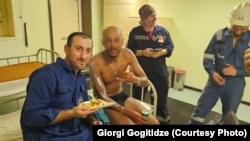 მეზღვაურები გადარჩენილ მიგრანტთან ერთად