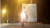 A screen grab from a video published on social media showing protesters setting fire to government propaganda banners in the southwestern Iranian city of Yasuj on February 20. 