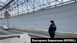 Полицейский патрулирует забор вокруг Охтинского мыса