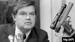 Predsjedavajući Obavještajnog odbora Senata SAD Frank Church, pokazuje pištolj s otrovnom strelicom 17. septembra 1975. tokom istrage Centralne obavještajne agencije na saslušanju u Vašingtonu.agencije.