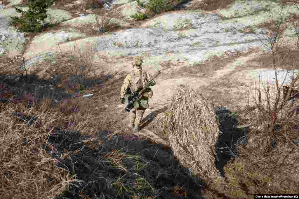 Dva ukrajinska vojnika hodaju stazom. Kao primjer utjecaja jednog snajperskog metka na neprijateljske snage, Elanskij navodi incident tokom borbi oko Kjupjanska na sjeveroistoku Ukrajine. &quot;Naš snajperist je pogodio ruskog vojnika sa udaljenosti od oko 800 metara&quot;, rekao je on. &quot;Samo jedan hitac i šta se desilo? Duž cijele linije fronta, svi [Rusi] su stavili pancire i šljemove. U samo jednom danu. To je cilj snajperiste - zabrinuti ih. Shvatili su da ovo nije izletište, da su došli u tuđinu u kojoj nisu dobrodošli.&quot;