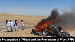 Pripadnici talibanske moralne policije pored lomače s muzičkim instrumentima i opremom koju su zaplenili u gradu Herat na zapadu Avganistana 29. jula.