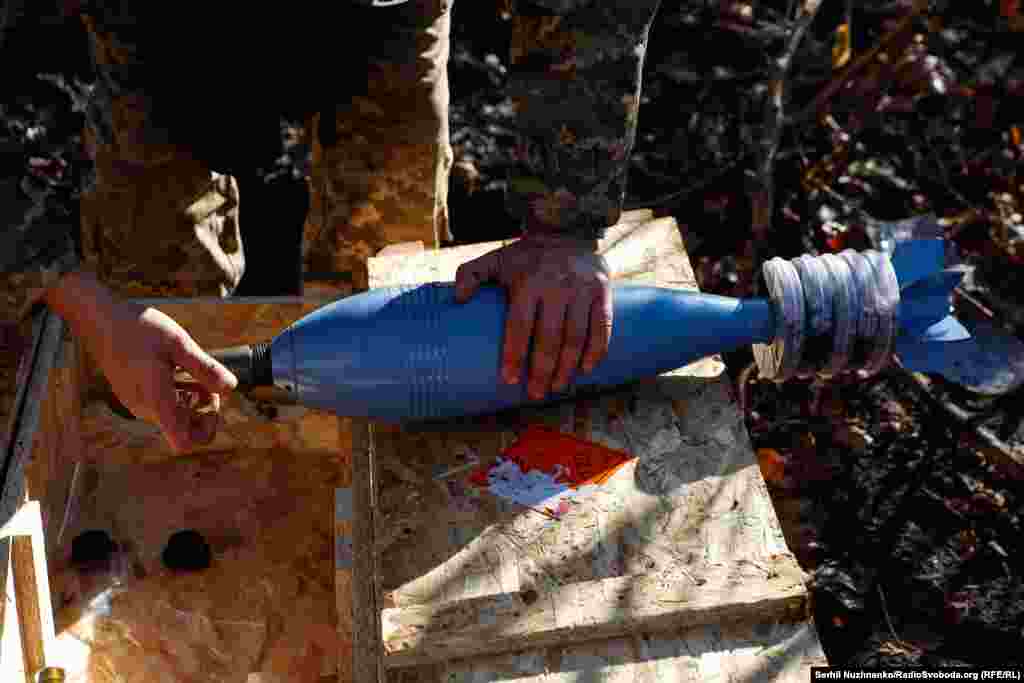 Još jedna granata je spremna za upotrebu. Iako je fotograf Serhij Naznenko tu da fotografiše, često je u centru pažnje jer su vojnici željni vijesti o tome šta se događa daleko od fronta i zasipaju ga pitanjima.