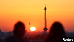 Ljudi gledaju izlazak sunca koje obasjava horizont Berlina, Njemačka, 7. septembra 2023.