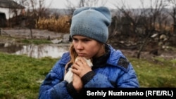 9-летняя девочка Софийка обнимает свою морскую свинку во время эвакуации из Макеевки на востоке Луганской области, 19 ноября 2022 года