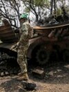 Украинские военнослужащие осматривают уничтоженную российскую БМП-2 в селе Сторожевое Донецкой области, освобожденном от российской армии, 14 июня 2023 года
