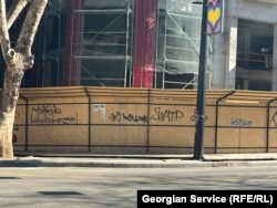 წარწერა ვარაზის ხევის ამოსასვლელთან, სამშენებლო ღობეზე, ფოტო გადაღებულია 28 მარტს. დღეს ეს წარწერა სარეკლამო პლაკატებითაა გადაფარული