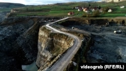 Sanski Most, Bosna i Hercegovina -- Snimak dronom bicikliste na putu pored provalije izazvanog iskopavanjem.