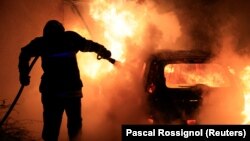 Vatrogasac gasi požar pete noći nemira posle policijskog ubistva 17-godišnjeg mladića, Turkoan, 2. juli 2023.