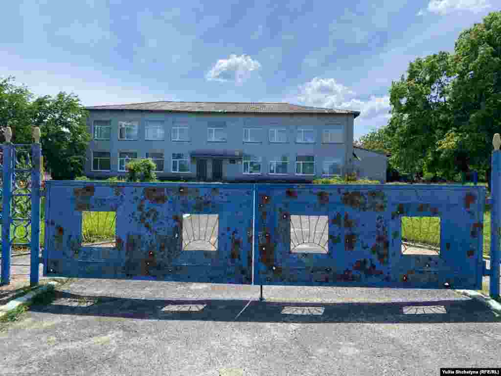 Дитячий садок «Колосок» у селі Новодмитрівка. Місцеві кажуть, що російські військові використовували приміщення для проживання своїх солдатів. На передній частині фото – центральний вхід у садок, на воротах – залишки від пострілів.