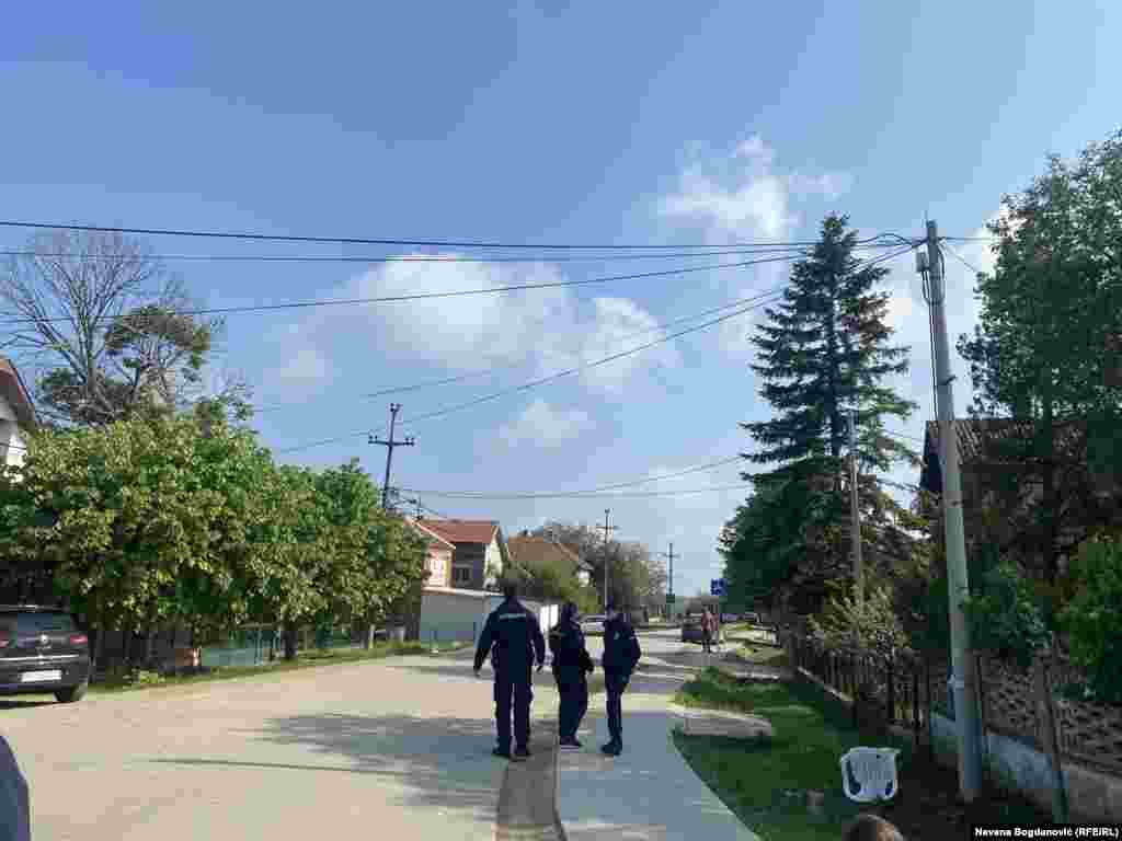 Veliki broj policajaca obezbeđuje mesto zločina. U selu vlada muk i tišina, čuju se samo crkvena zvona.