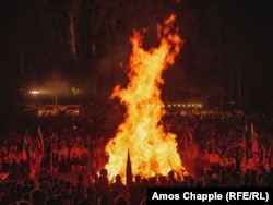 Posjetioci gledaju veliki zapaljeni oganj.