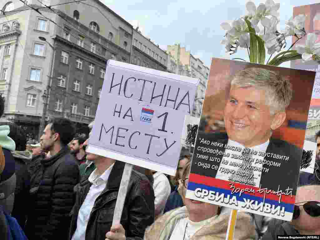 'Istina na 1. mestu', piše u poruci koju nosi jedna od demonstranata, dok je na drugoj fotografija političara i bivšeg prijera Srbije Zorana Đinđića ubijenog u atentatu u martu 2023. godine ispred zgrade Vlade Srbije. Na plakatu je jedan od citata Đinđića i poruka 'Srbija živi'. Beograd, 30. decembar 2023.