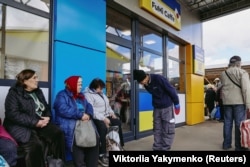 Фумінорі Цучіко вітає місцевих біля свого кафе в Харкові 27 квітня 2023 року