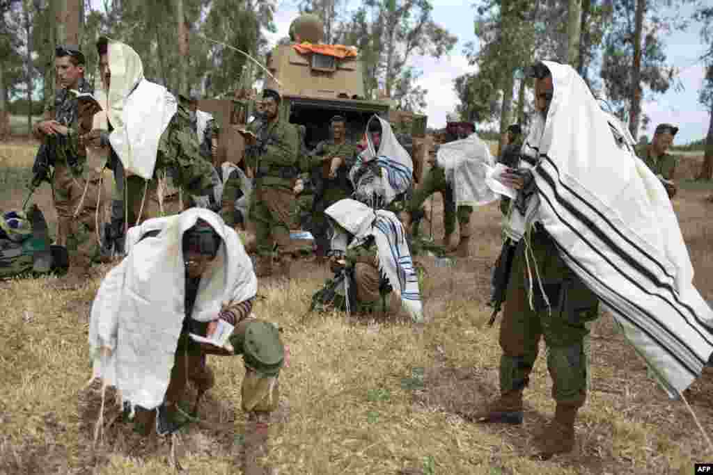 Dozvoljeno im je prakticiranje vjere, obavljanje molitve i učenje, ali im je ograničena interakcija sa vojnikinjama. Na fotografiji: Vojnici bataljona Netzah Yehuda obavljaju jutarnju molitvu koja podrazumijeva i čitanje Tore, tokom obuke na Golanskoj visoravni u blizini sirijske granice, 19. maja 2014.