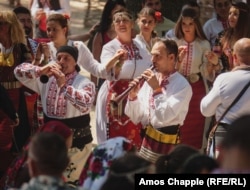 Muzičari sviraju u krugu plesača.