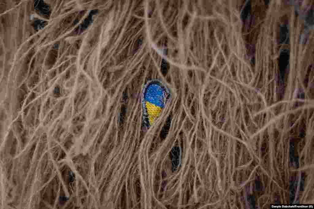 Sitna oznaka ukrajinske zastave skrivena u kikimori. Katerina već više od pet godina služi u ukrajinskoj vojsci i ima planove nakon što njena zemlja dobije rat. &quot;Želim da putujem svijetom, da vidim Španiju i Finsku i ponovo posjetim Ameriku&quot;, kaže ona. Najteže je, kaže ona, suočiti se s činjenicom da sukob izazvan ruskom invazijom vjerovatno neće uskoro biti okončan. &quot;Dajete veliki doprinos [odbrani Ukrajine], ali kraj se još ne nazire.&quot;