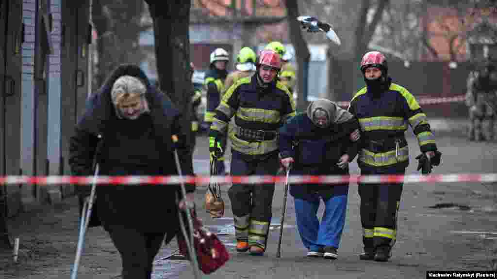 Osoblje prve pomoći pomaže stanovnicima da napuste svoje domove nakon raketnog napada.