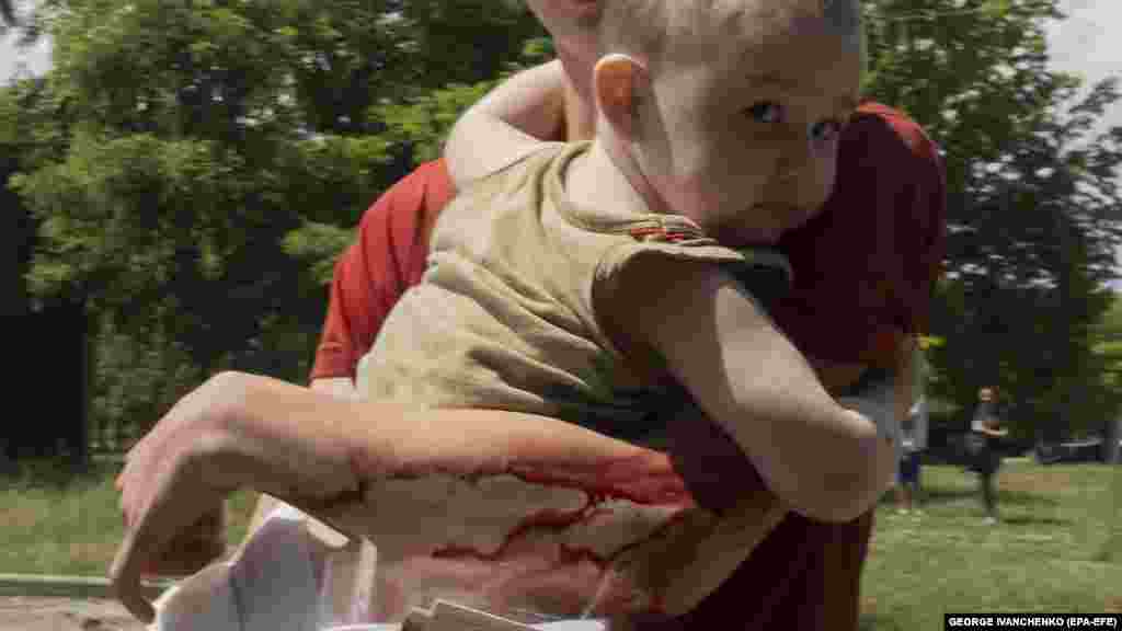 Ozlijeđeni mladić odnosi malo dijete iz stambene zgrade.