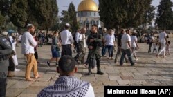 Izraelski policajci prate jevrejske posetioce dok slave Pashu u kompleksu džamije Al Aksa u Starom Jerusalimu, tokom svetog meseca Ramazana, u nedelju 9. aprila 2023.