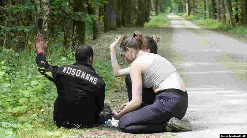 Poljska aktivistica pruža pomoć alžirskom migrantu koji je stigao na teritoriju Poljske u Bjelovjeskoj šumi. Broj pokušaja ilegalnog prelaska granice iz Bjelorusije u Poljsku, članicu EU, porastao je posljednjih mjeseci na skoro 400 dnevno u odnosu od samo nekoliko po danu ranije ove godine, kažu poljski zvaničnici.  