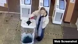 Foto načinjen iz video snimka: Žena ubacuje zelenu boju u glasačku kutiju na ruskim izborima, mart 2024.
