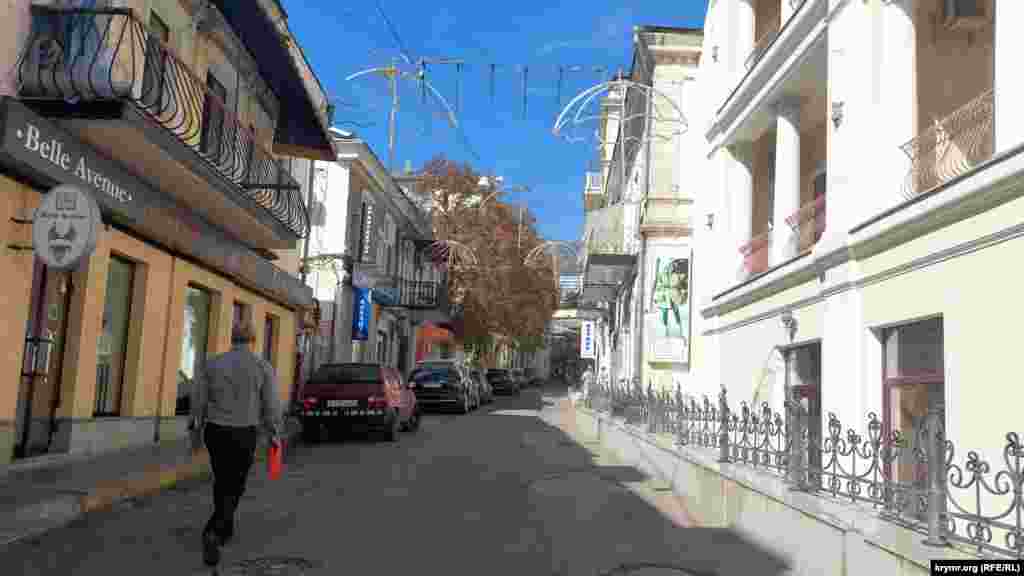 Если на набережной еще можно увидеть немногочисленных прохожих, то буквально стоит шагнуть за угол – и открываются виды улиц, по которым спешат по своим делам редкие прохожие. До аннексии Крыма здесь было не протолкнуться от отдыхающих, однако с 2014 года количество туристов постепенно уменьшалось