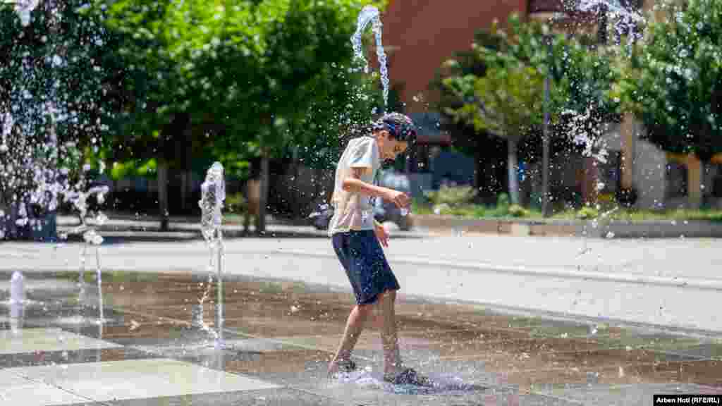 Dečak se pršće da se ohladi od velikih vrućina u Prištini, 18. jula 2023. godine 