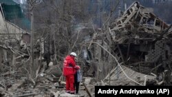 მედიცინის მუშაკი ანუგეშებს ქალს რუსული ავიაიერიშის ადგილზე, ზაპოროჟიე. 2024 წლის 22 მარტი