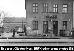 Isti policajac kao na prethodnoj fotografiji uperio je pištolj u drugog uniformiranog muškarca koji drži kalašnjikov.