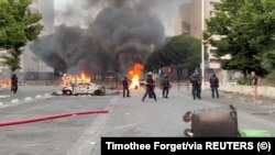 France - Fire burns near police officers in the aftermath of a clashes between protesters and police,Toulouse, France June 28, 2023