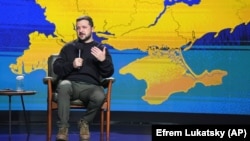 Владимир Зеленский выступает на фоне карты Украины, включающей Крым