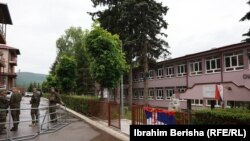 Pripadnici KFOR-a propuštaju stanara zgrade u blizini opštinskog objekta