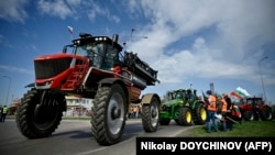 Земеделски производители карат тракторите си по време на акция за блокиране на камионите, преминаващи през Дунав мост, в знак на протест срещу безмитния внос на зърно от Украйна в ЕС, в Русе на 29 март 2023 г. 