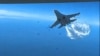 A Russian Su-27 aircraft dumps fuel while flying upon a U.S. Air Force intelligence, surveillance, and reconnaissance unmanned MQ-9 aircraft over the Black Sea, March 14, 2023 in this still image taken from a handout video
