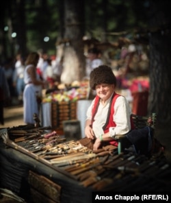 Čovjek na štandu prodaje ručno izrađene noževe.