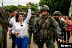 Кандидат в президенты Эквадора Луиса Гонсалес идет на избирательный участок в городе Кануто в сопровождении полиции. Фото: Reuters