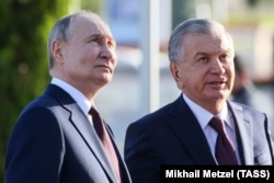 Президент России Владимир Путин и президент Узбекистана Шавкат Мирзиеев во время возложения цветов к мемориалу "Ода стойкости" во время посещения мемориального комплекса "Парк Победы". Ташкент, 27 мая 2024 года