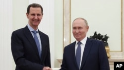 Sirijski predsjednik Bashar al-Assad i ruski predsjednik Vladimir Putin rukuju se tokom sastanka u Moskvi 24. jula. Kremlj je 9. decembra saopštio da je Putinova odluka da Assadu odobri azil u Rusiji.