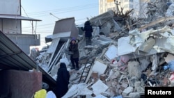 Duminică, pe 12 februarie, oamenii din orașul Elbistan, regiunea Kahramanmaraș, își caută lucrurile printre dărâmături.