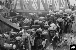 Na ovoj fotografiji od 22. juna 1967. palestinske izbjeglice nose svoje stvari dok se pripremaju prijeći srušeni most Allenby preko rijeke Jordan iz dijela Jordana koji je okupirao Izrael. Mnoge izbjeglice rekle su da su ih Izraelci natjerali da odu.