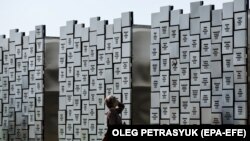 Жінка біля меморіалу жертвам воєнних злочинів у Бучі, Київська область, 17 вересня 2023 року