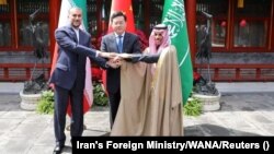 Iranian Foreign Minister Hossein Amir-Abdollahian (left), Saudi Arabian Foreign Minister Prince Faisal bin Farhan Al Saud (right), and Chinese Foreign Minister Qin Gang shake hands during a meeting in Beijing on April 6.