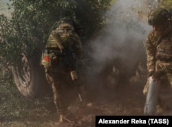 რუს ჯარისკაცს, რომელიც უკრაინის ლუგანსკის რეგიონში ჰაუბიცას ისვრის, საბჭოთა დროშის სამკლავური უკეთია. 4 ოქტომბერი.