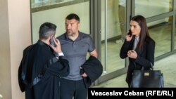 Evghenia Guțul, cu avocații ei, Vadim Banaru (cu spatele) și Sergiu Moraru, în holul Judecătoriei Buiucani, la una din ședințele de judecată.