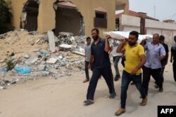 Palestinci nose tijelo nakon obavljene identifikacije iz masovne grobnice kod bolnice Nasser, na jugu Pojasa Gaze, 25. aprila 2024.