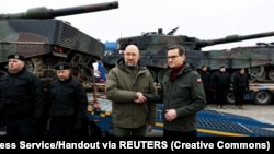 Первая годовщина войны: 24 февраля 2023 года премьер-министр Украины Денис Шмыгаль (слева) принимает у польского коллеги Матеуша Моравецкого поставленные Польшей танки